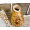 This shows the rim of the natural vase has been carved with a textured stippled effect. The rim is light beige.
